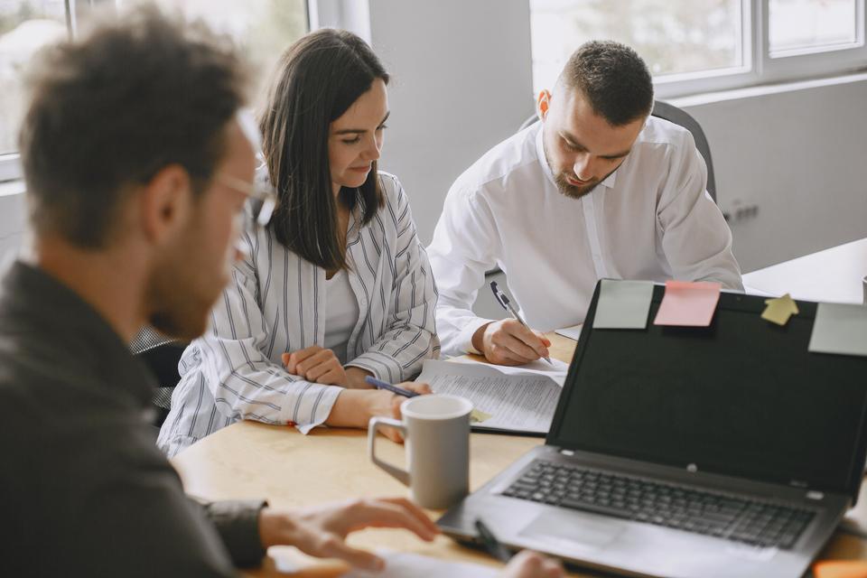 Un equipo revisa información junto a un portátil.